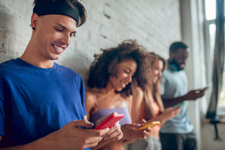 Surfing the internet. A group of young people using their smartphonesの写真素材