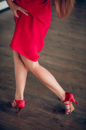 Woman wearing a red dress and heels during the rehearsalの写真素材
