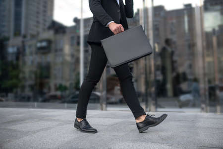 Business morning. Close up picture of a man with portfolio in the streetの写真素材