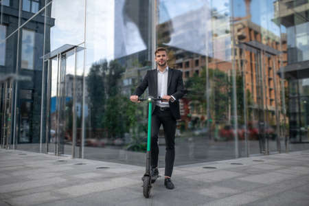 Vehicle. Young businessman with the scooter in the street