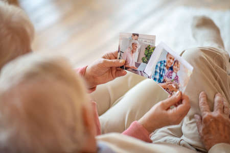 Memories. Close up picture of people looking through old photographsの写真素材