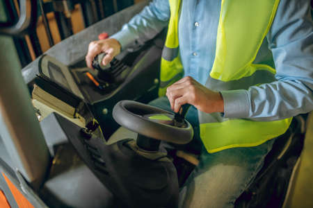 Driving the loader. Close up picture of amn sitting in the loader