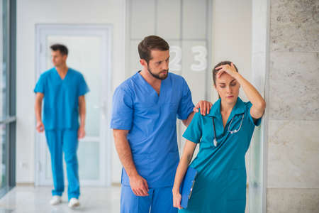 Friendly support. Female doctor feeling happy while her male colleague supporting her