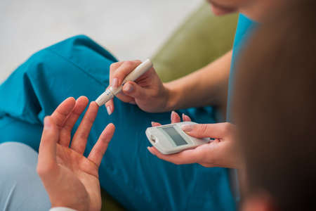 Diabetes. Close up picture of humans hands and glucometer