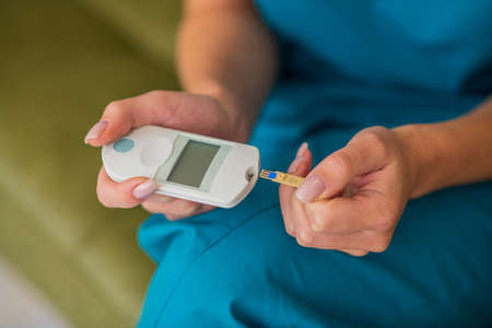 Diabetes. Close up picture of female hands doing test on blood glucose