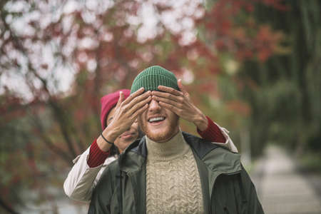 Waiting for surprise. A woman closing her boyfriends eyes while walkingの写真素材