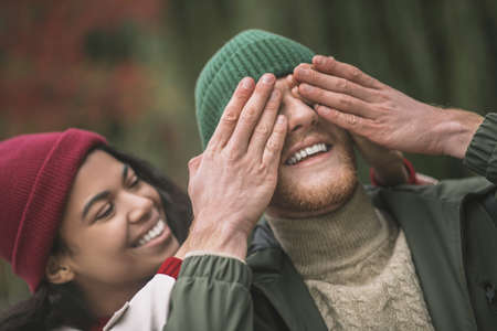 Closing eyes. A woman preparing a surprise for her boyfriendの写真素材