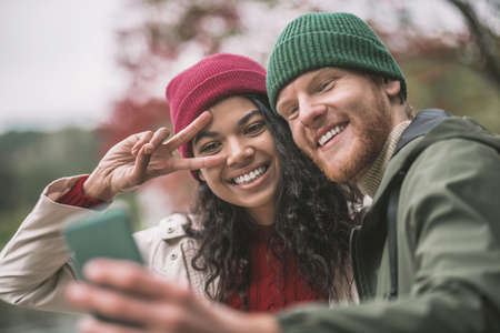 Mobile shooting. A happy couple taking pictures with a smartphoneの写真素材
