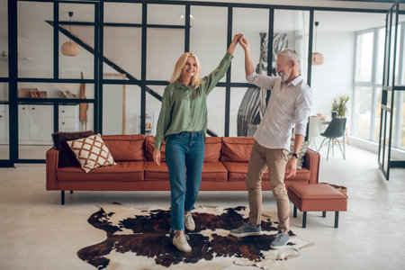 Dancing. Man and woman dancing in the room and feeling goodの写真素材