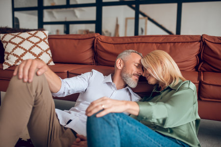 Relaxed. Mature couple sitting on the floor and looking relaxedの写真素材
