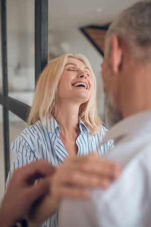 Happy woman. Blonde woman hugging her boyfriend and smiling happilyの写真素材