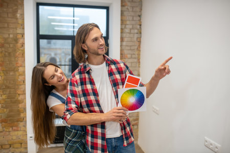 New house. Young couple discussng the wall color in a new house and smiling