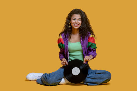 Wonderful mood. Cute dark-haired young girl holding a record and feeling gorgeousの写真素材