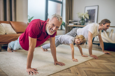 In plank. Two men and their son standing in plank and smilingの写真素材