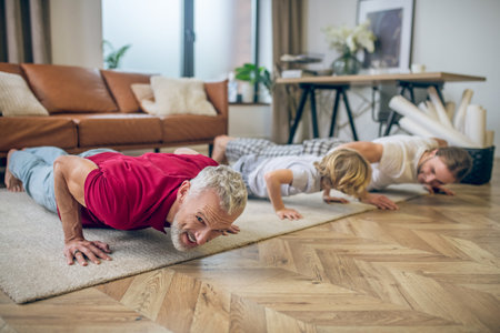 Push ups. Two men and their son doing push ups and looking good
