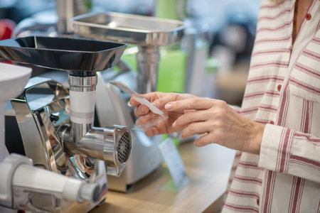 Goods for kitchen. Close up picture of a woman choosing goods for kitchen