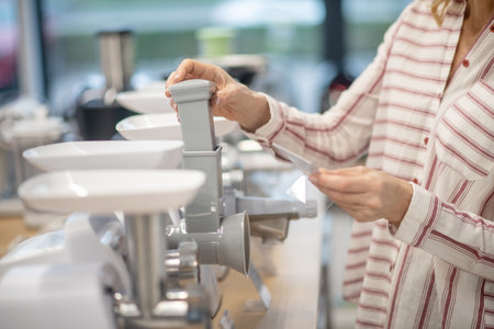 Goods for kitchen. Close up picture of a woman choosing goods for kitchen