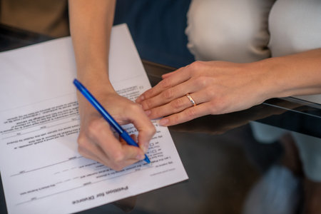 Divorcing decision. A woman signing a petition for divorce formの写真素材