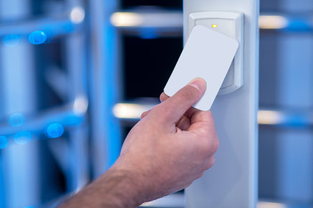 Scanning device. Male hand applying an electronic badge to scanning device near turnstile at...