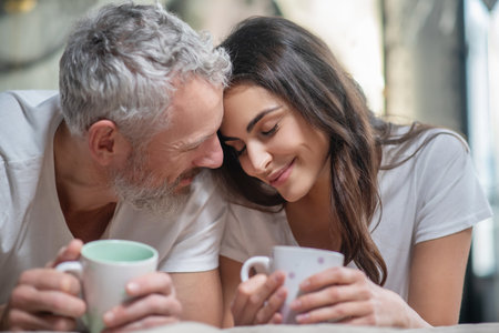 Enjoying tenderness. A lovely couple having their mornng coffee togetherの写真素材