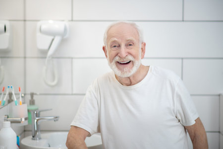 Good mood. Gray-haired man in white tshirt laughing vigorouslyの写真素材