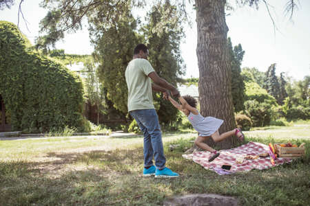 In the park. African american man and his daughter having fun in the park