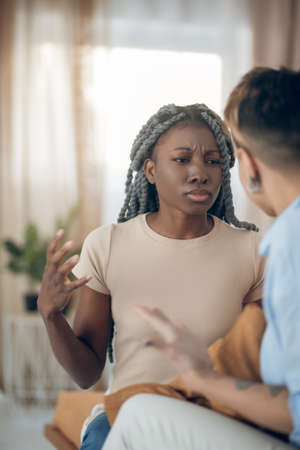 Argument. Dark-skinned girl talking to her girlfriend and looking agressiveの写真素材