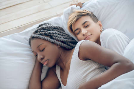 Sleeping. Two girls sleeping together in the bedの写真素材
