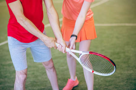 Playing tennis. Close up picture of man and woman holding a racketの写真素材