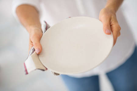 Kitchen. Close up picture of a woman with plate in handsの写真素材