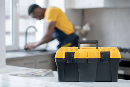 Busy. Dark-skinned service man working in the kitchen and looking concentrated on work