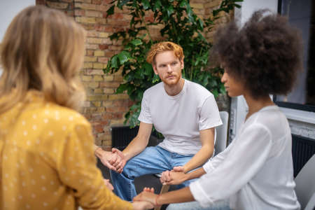 Psychological support. People sitting in na circle and holding hands