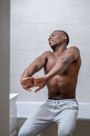 African american sporty guy looking sleepy and stretchingの写真素材