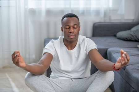 Handsome african american guy meditating and looking peacefulの写真素材