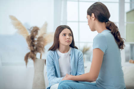 Sad cute girl and calm understanding mom