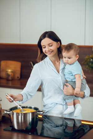 Woman with child experienced housewife cooking spaghettiの写真素材