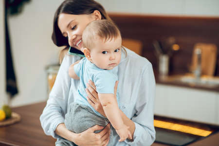 Happy woman with child talking on smartphone