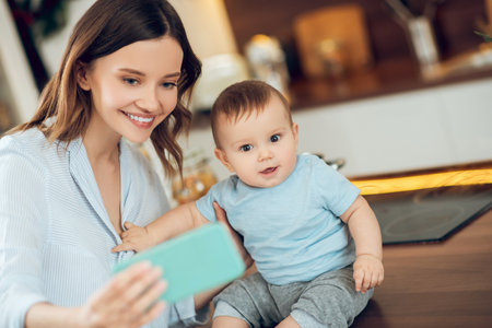 Mom with child taking selfie on smartphoneの写真素材