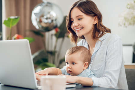 Mom with small child sitting at laptopの写真素材