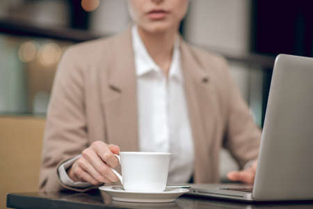 Beautiful young businesswoman having coffee in the officeの写真素材