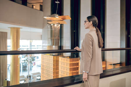 Elegant businesswoman in beige jacket swaiting for her colleagueの写真素材
