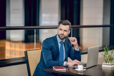 Young businessman in a nice suit working in the office and looking concentratedの写真素材