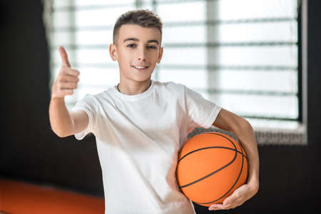 A cute boy with a ball looking contented