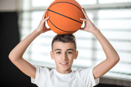 A cute boy with a ball feeling good and contentedの写真素材