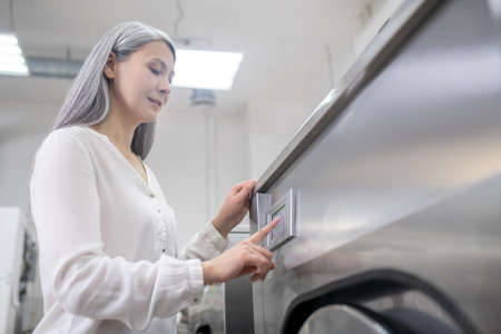 Woman near washing machine at dry cleaning