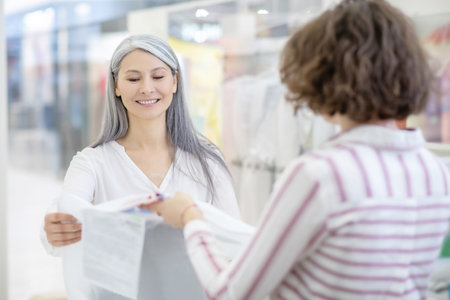 Dry cleaning customer taking clothes in caseの写真素材