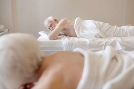 Senior woman lying on na couch in a spa salonの写真素材