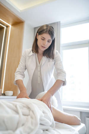 Massage therapist doing back massage to a senior female clientの写真素材