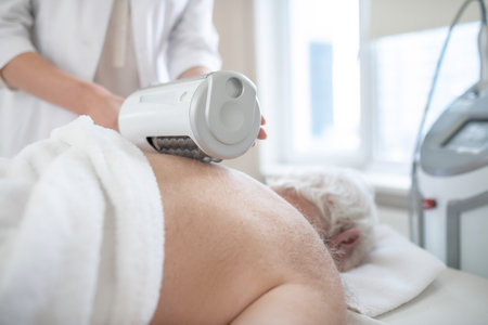 Physiotherapist doing anti-ostechondrosis procedures to a female patientの写真素材