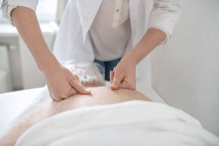 Massage therapist working with an elderly male patient